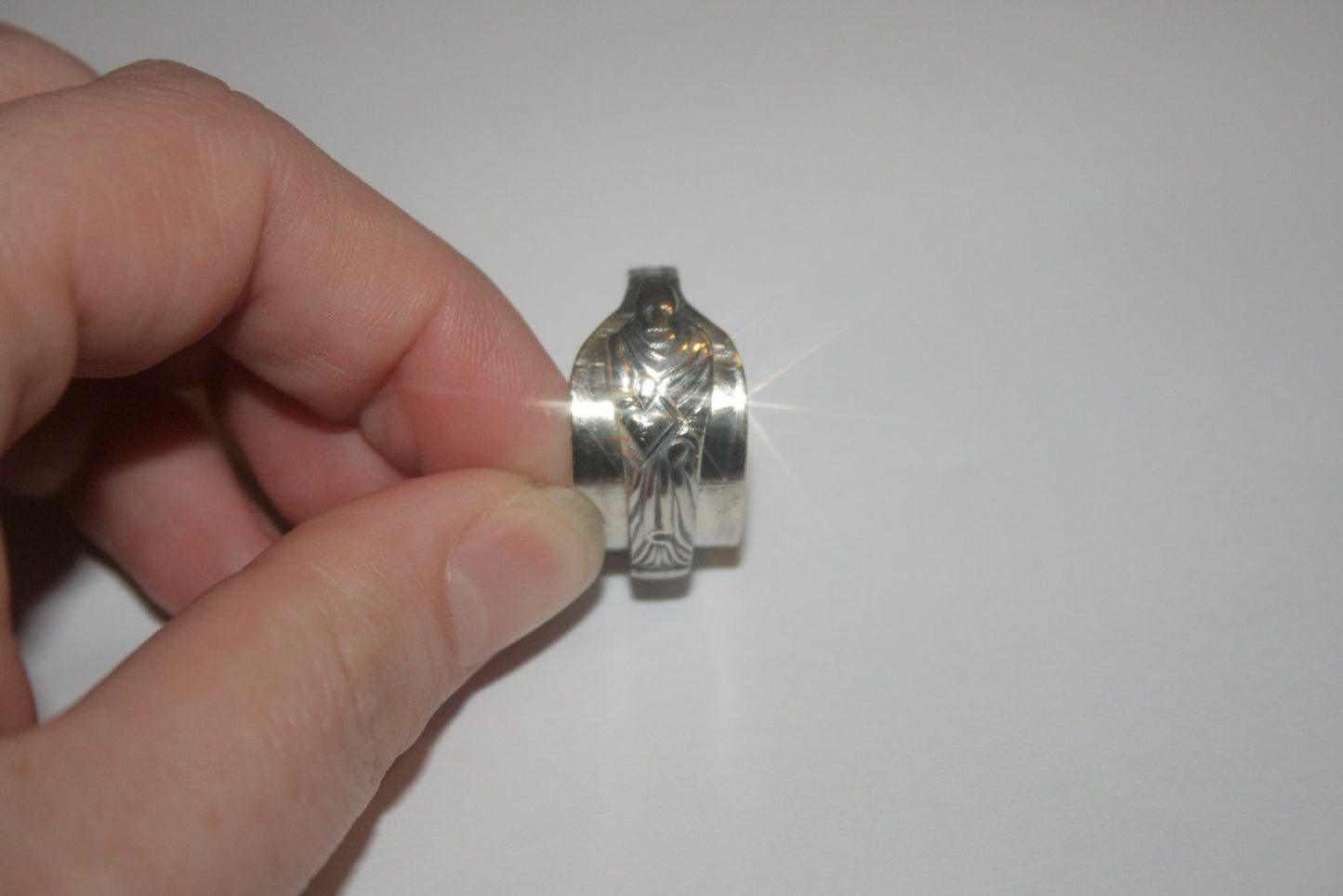 Upcycled silver ring made from antique apostle spoon with detailed apostle figure held upright by a woman