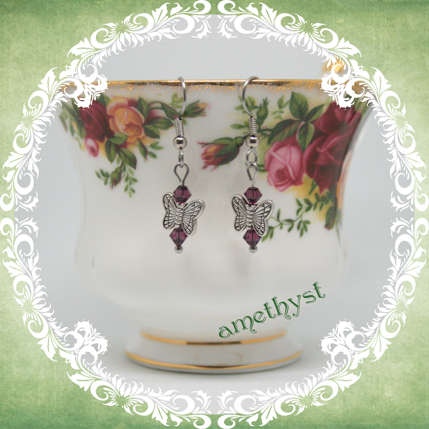 Handmade silver butterfly earrings with amethyst crystal beads shown on floral china teacup
