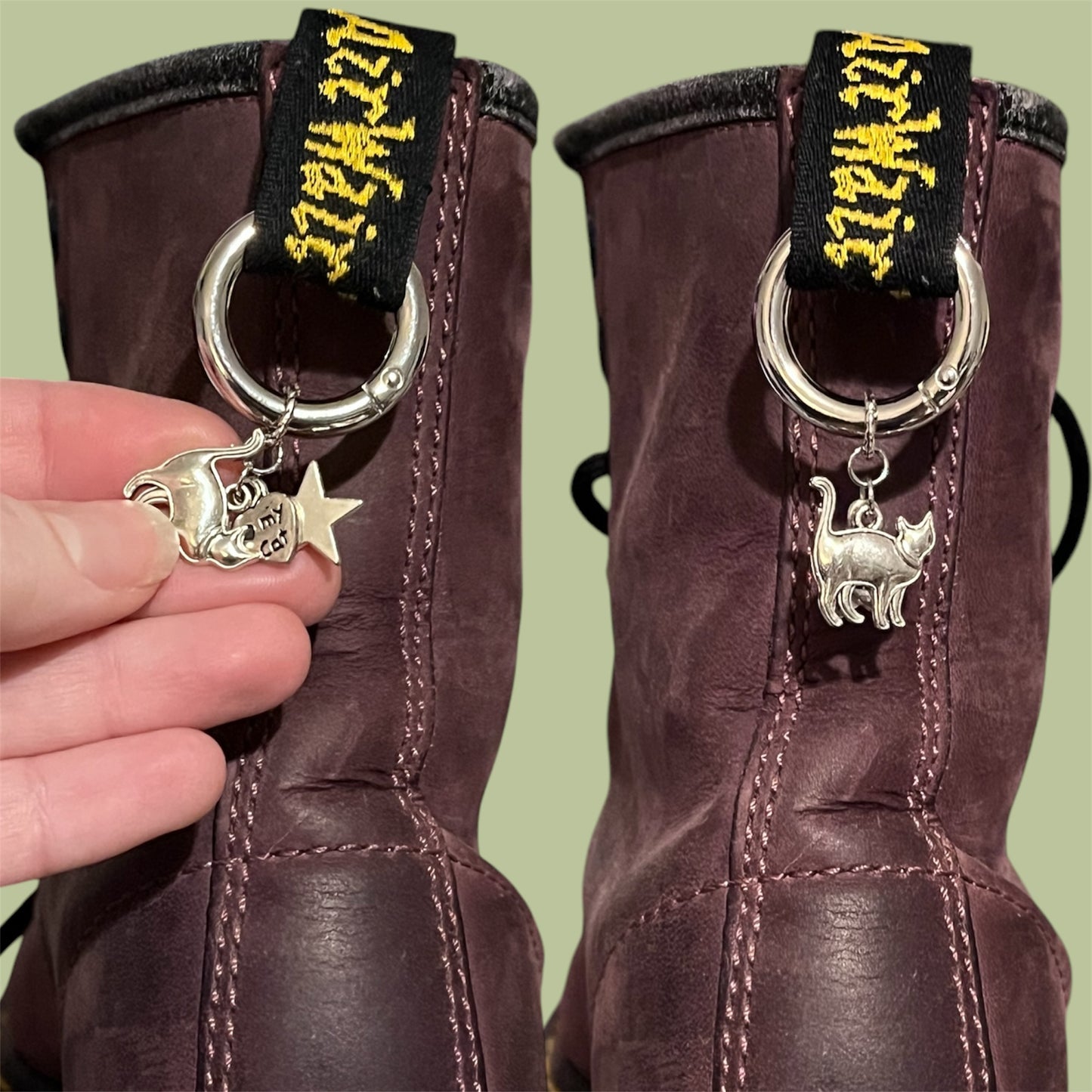 Close-up of handmade silver boot charms with standing cat, heart reading heart my cat, and solid star designs clipped onto black boot tabs