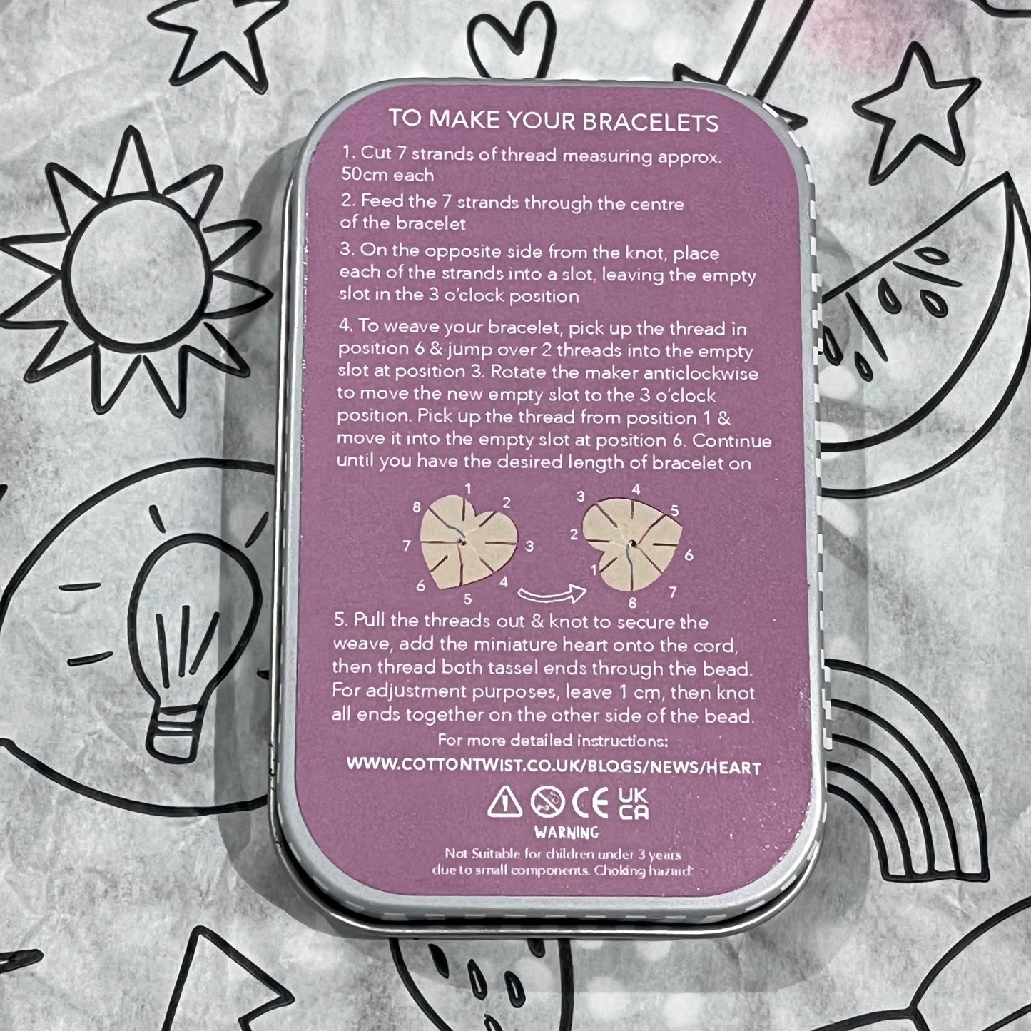 Plastic-free kids friendship bracelet kit with heart-shaped bracelet tools, wooden beads, pastel threads, and heart charms, back of box