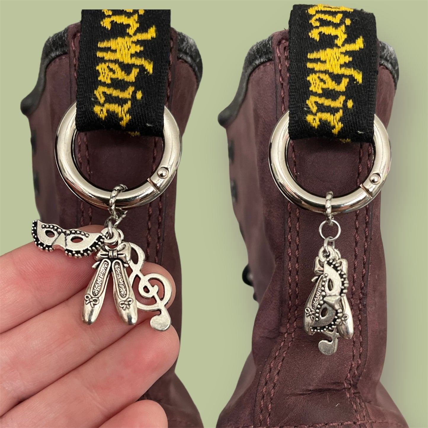 Close-up of handmade silver boot charms with opera mask, ballet shoes, and treble clef designs clipped onto black boot tabs
