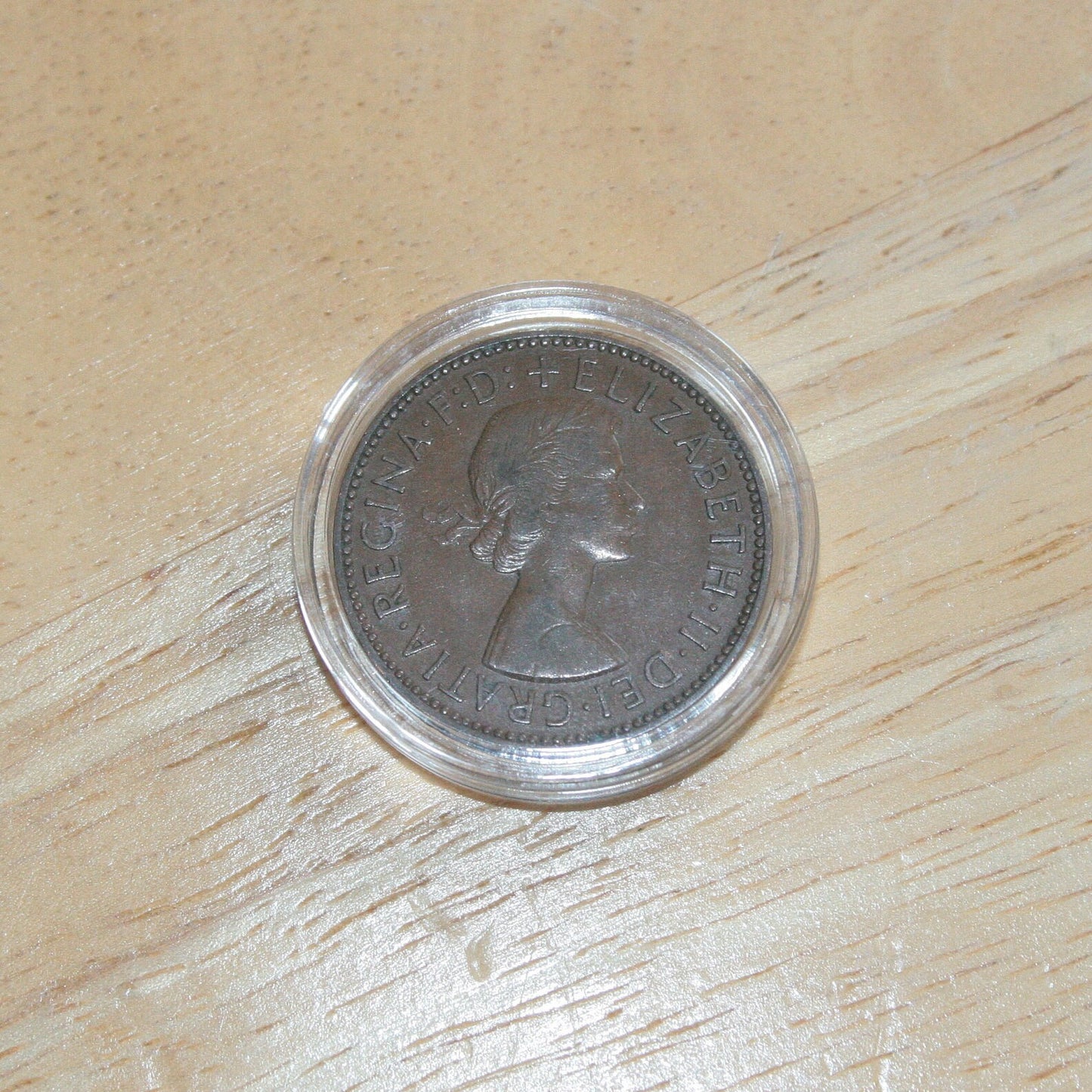 Queen Elizabeth II copper half penny coin in protective capsule, obverse dull