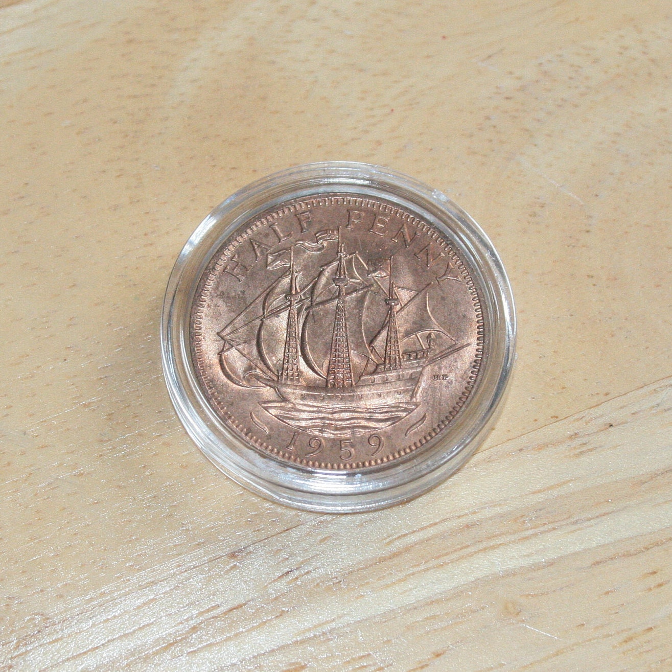 Queen Elizabeth II copper half penny coin in protective capsule, reverse 1959