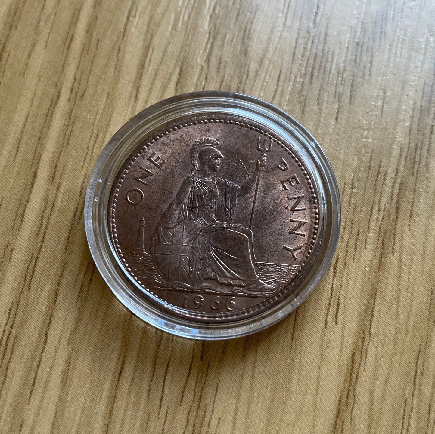 Queen Elizabeth II copper one penny coin in protective capsule, reverse