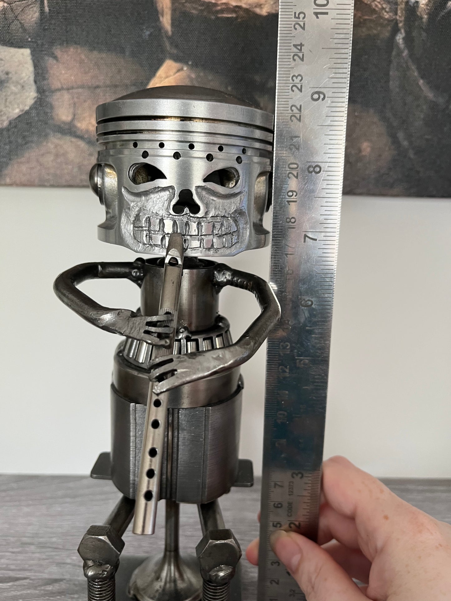 Close-up of upcycled metal tin whistle player sculpture with piston skull head, crafted from recycled motorbike parts — industrial-style music-themed home decor or musician gift, showing height measurement.
