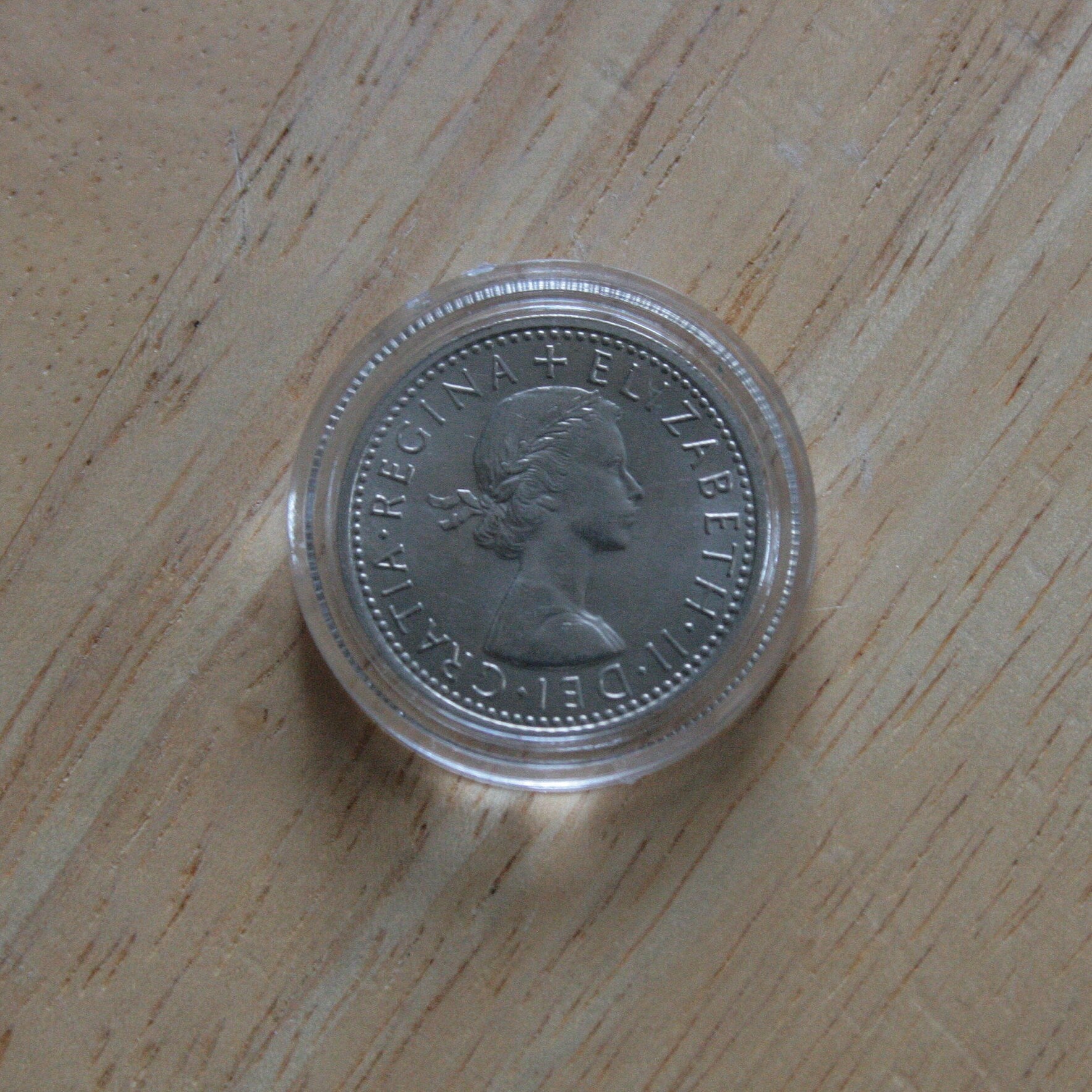 Queen Elizabeth II silver sixpence coin in protective capsule, obverse