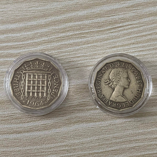 Queen Elizabeth II brass threepence coins in protective capsules, obverse and reverse