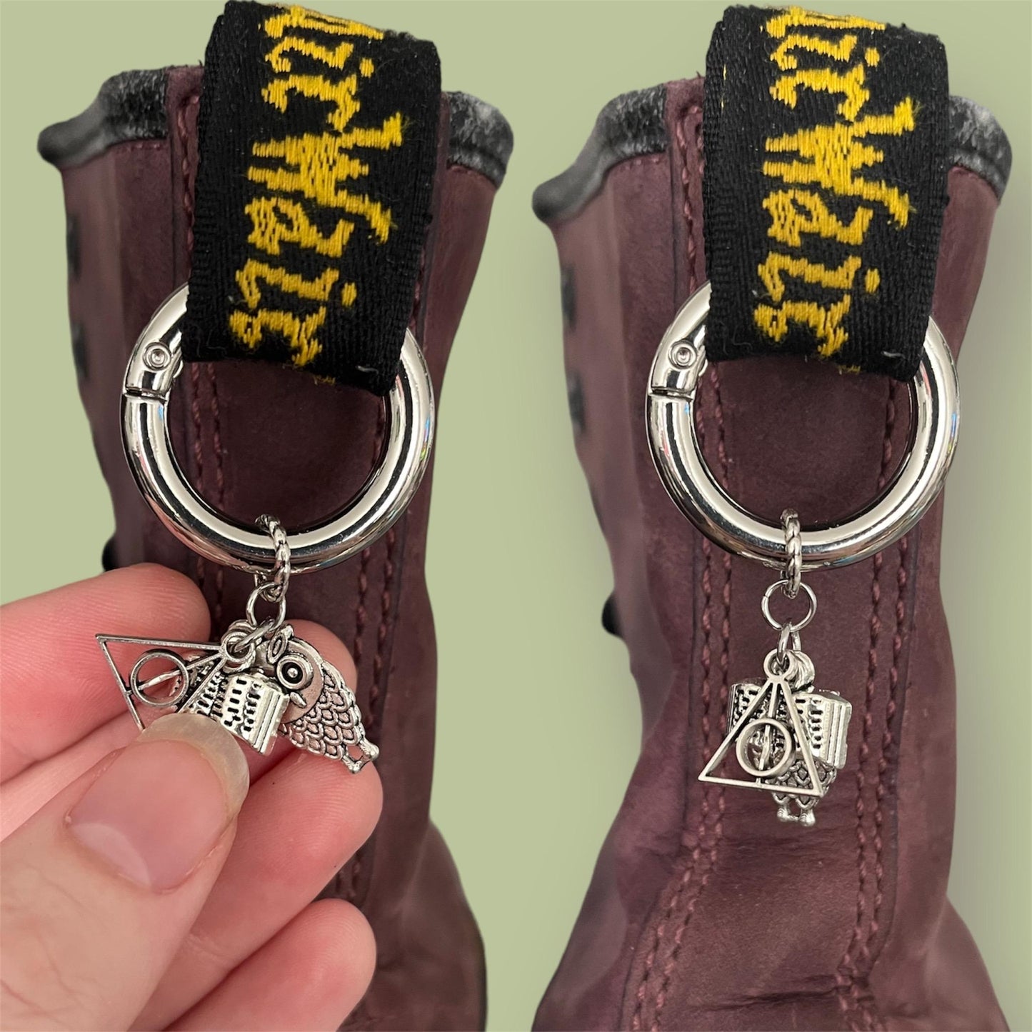 Close-up of handmade silver boot charms with Harry Potter themed designs clipped onto black boot tabs. The designs are a triangle with circle and a line through it, an open book, and an owl.