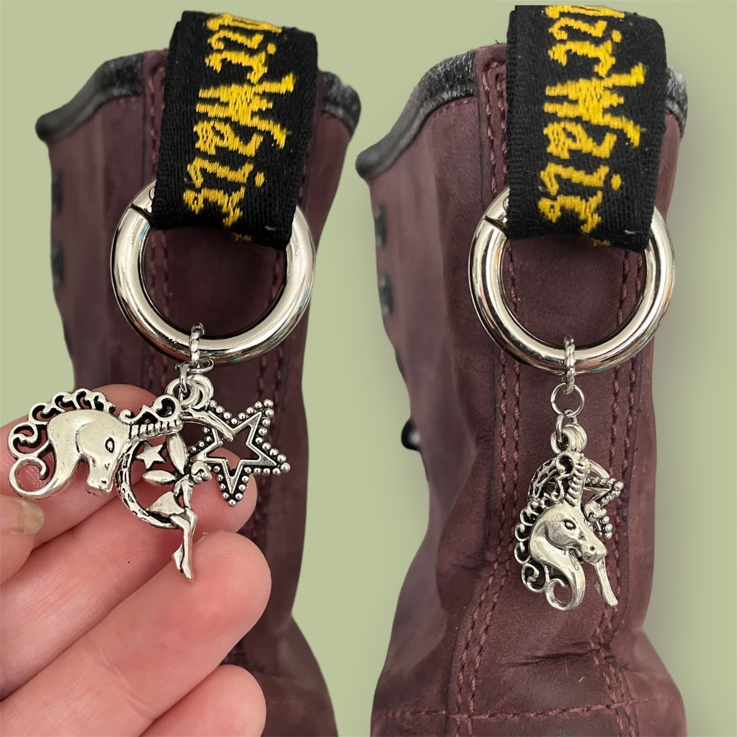 Close-up of handmade silver boot charms with unicorn head, fairy sitting on a crescent moon, and open star designs clipped onto black boot tabs