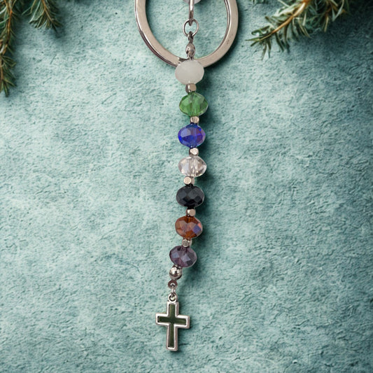 Psalm 23 keyring with glass beads and cross charm. Pictured on green textured background.