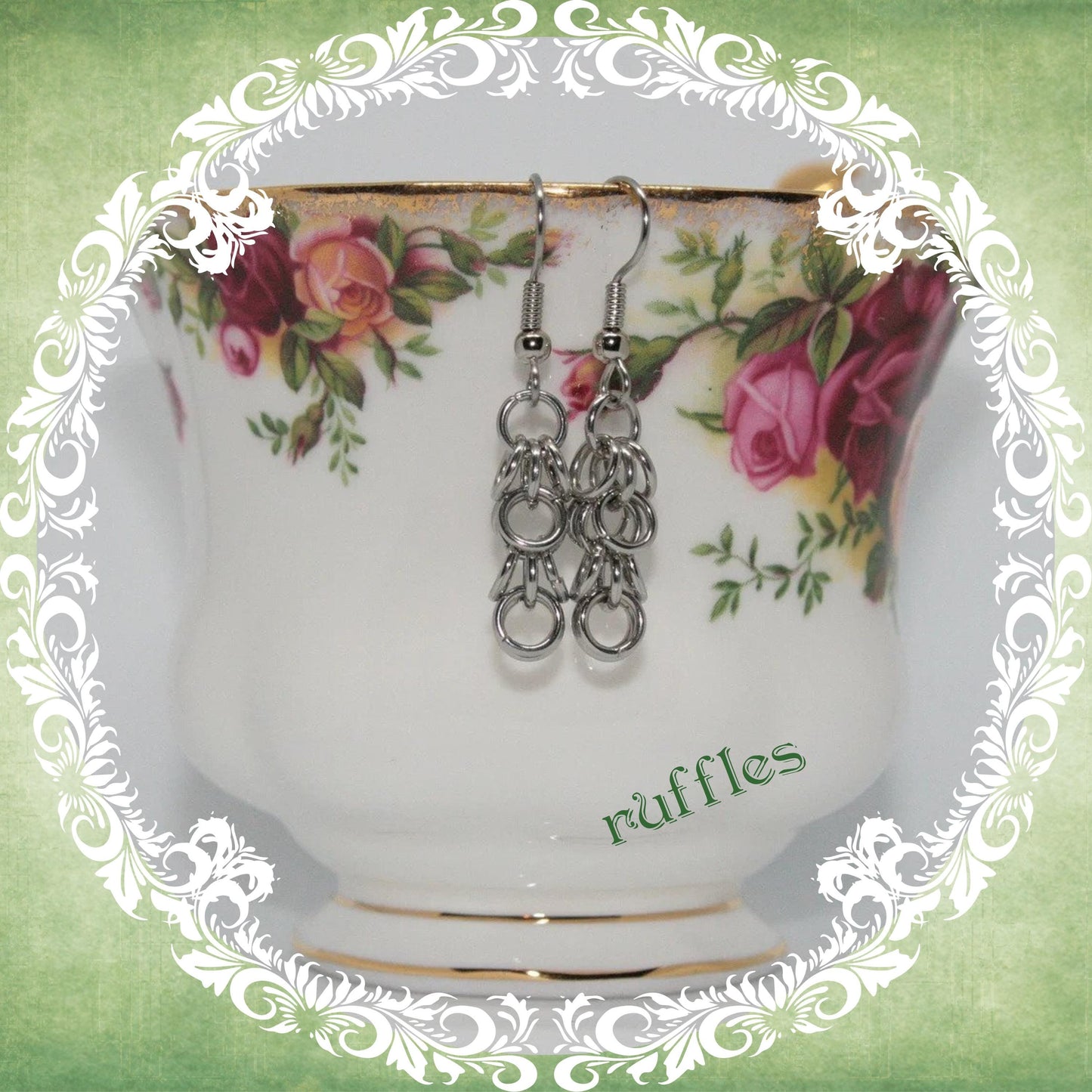 Handmade stainless steel chainmail dangle earrings shown on vintage floral teacup, modern medieval fashion accessory, ruffles design
