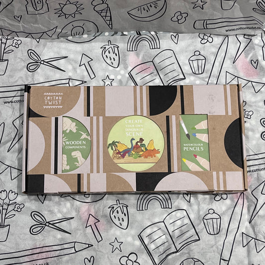 Plastic-free kids dinosaur craft kit with wooden dinosaur cutouts, watercolor pencils, brush, and stand, box closed
