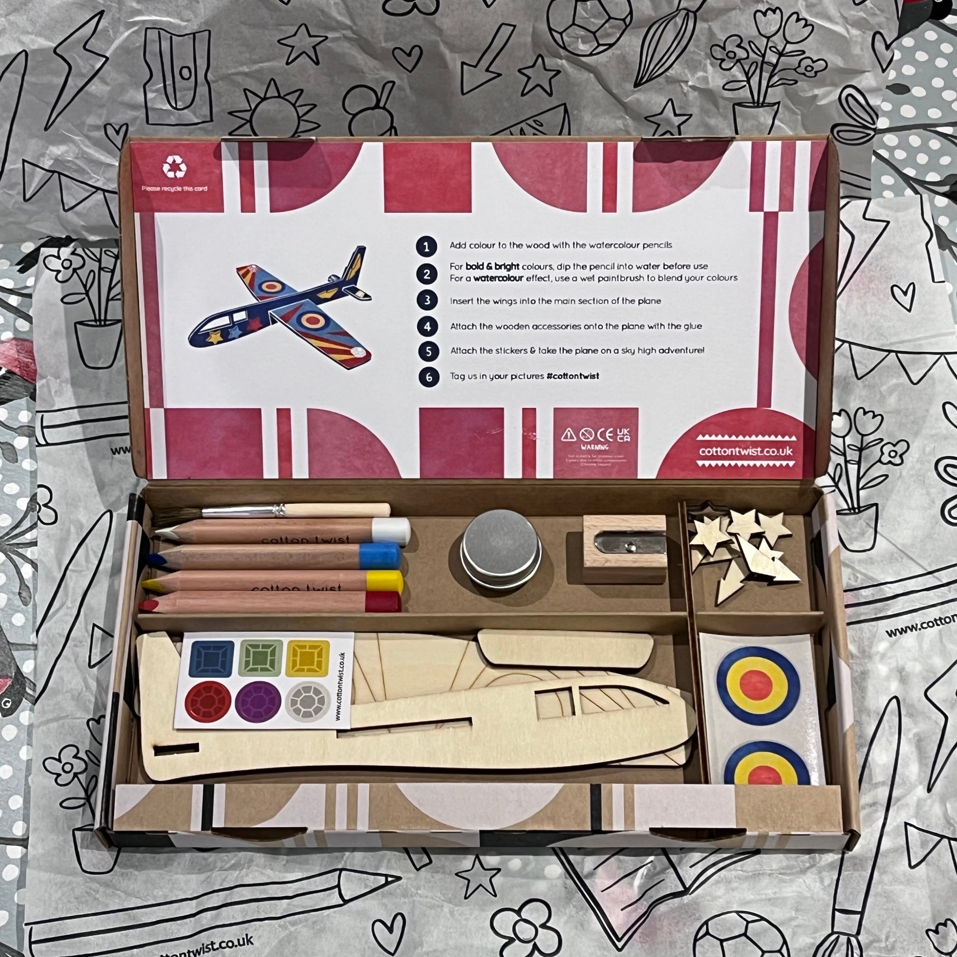 Plastic-free kids plane craft kit with wooden plane cutouts, watercolor pencils, brush, and stickers, box open