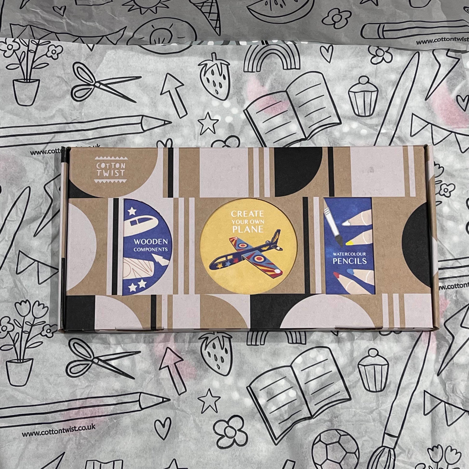 Plastic-free kids plane craft kit with wooden plane cutouts, watercolor pencils, brush, and stickers, box closed