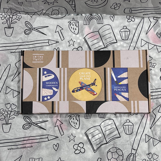 Plastic-free kids plane craft kit with wooden plane cutouts, watercolor pencils, brush, and stickers, box closed