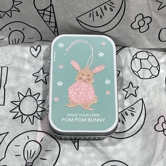 Plastic-free kids pom-pom bunny craft kit with wooden bunny cutout, wool, watercolor pencils, brush, and wooden needle, front of box