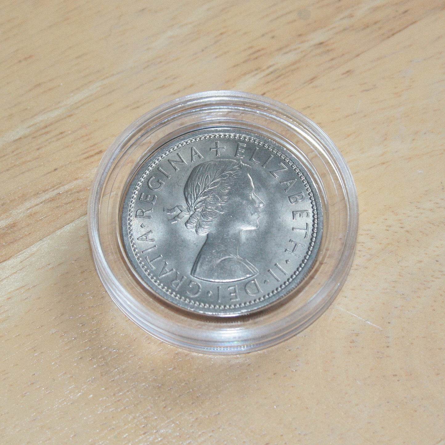 Queen Elizabeth II silver two shilling coin in protective capsule, obverse