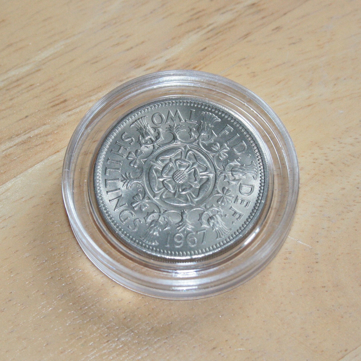 Queen Elizabeth II silver two shilling coin in protective capsule, reverse 1967