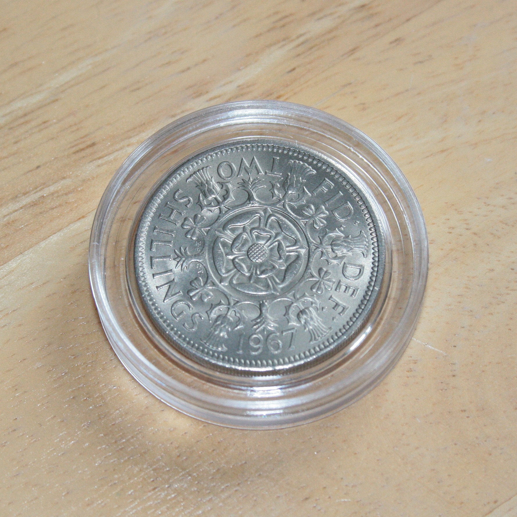Queen Elizabeth II silver two shilling coin in protective capsule, reverse 1967